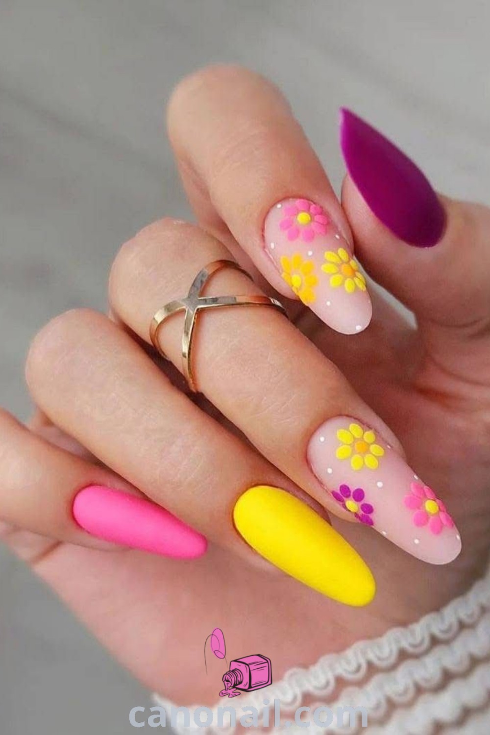 Spring nails featuring bright and multicolored designs on chic almond nails. Vibrant yellows and artistic accents make for stunning nail art perfect for spring. Discover modern nail ideas and inspiration at canonail.com.