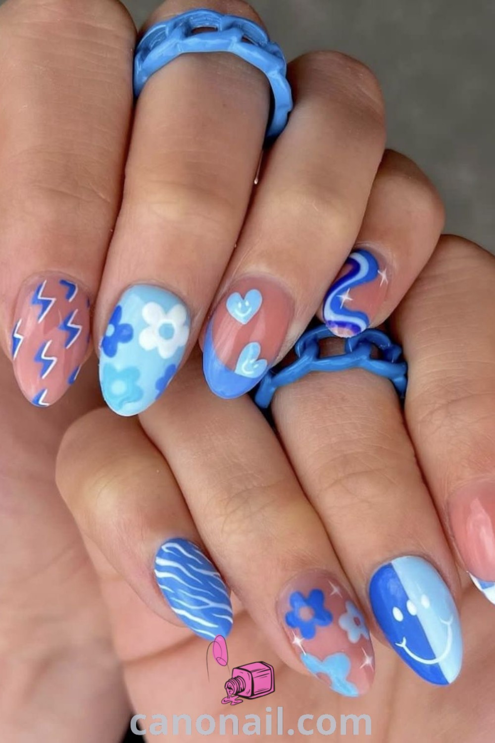 Spring nails on almond-shaped nails showcasing a floral nail design in soft blue acrylic, perfect for a beach goddess look. Discover more trendy summer nail ideas and stunning nail art at canonail.com.