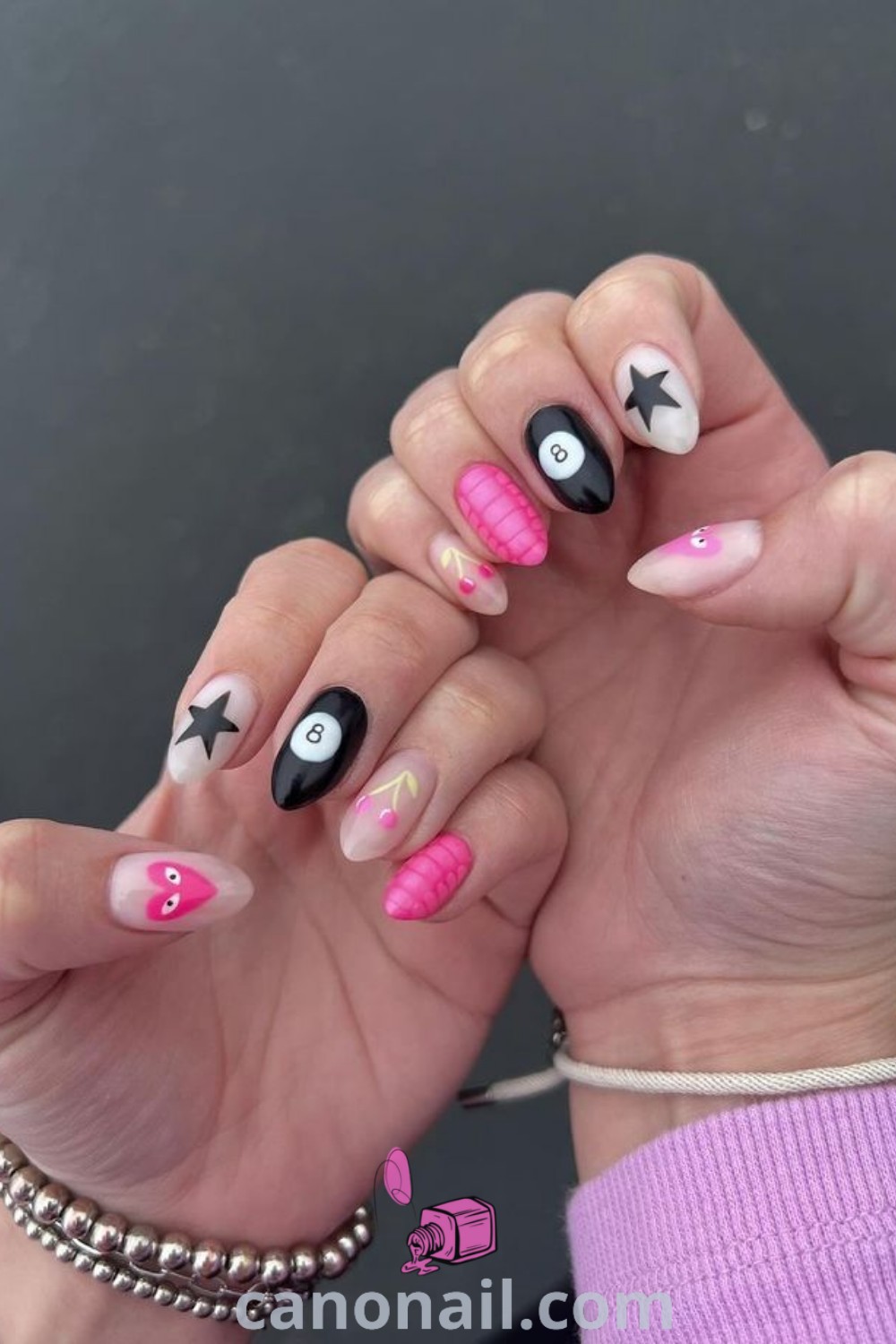 Spring nails with cute designs on almond-shaped nails featuring black, white, and pink colors. Includes trendy manicure styles like acrylic designs and a variety of nail art ideas. Find more stunning nail inspiration at canonail.com.