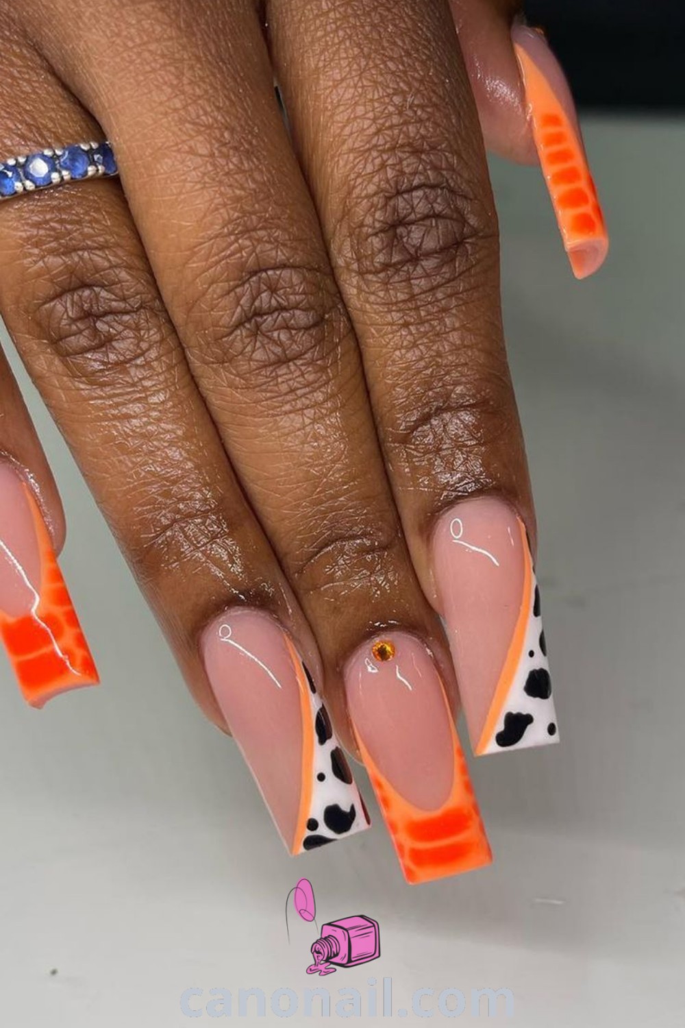Spring nails featuring square-shaped designs with bold nail art, bright orange hues, and trendy short styles. Perfect for vibrant summer looks. Discover more nail ideas at canonail.com.